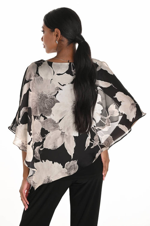 Woman wearing a floral patterned poncho against a white background