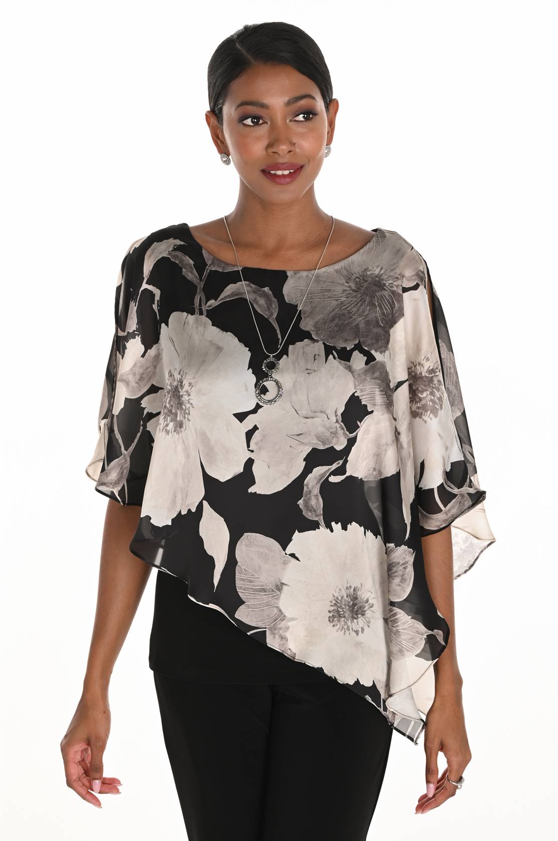 Woman wearing a floral blouse with black, white, and gray pattern on a white background