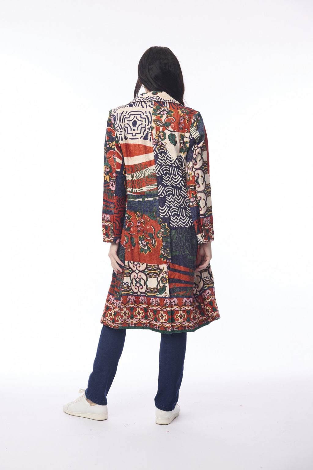 Person wearing a long, patterned coat on a white background