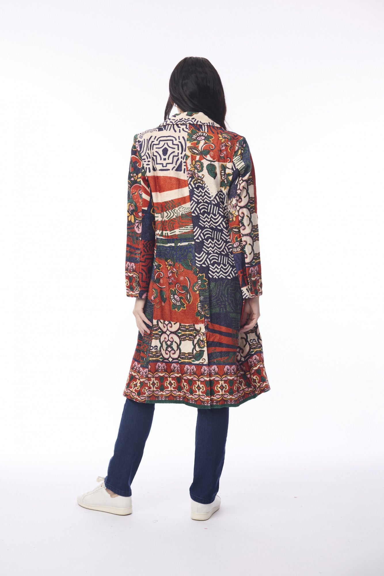 Person wearing a long, patterned coat on a white background